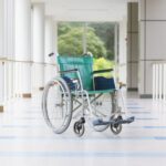 wózek inwalidzki stojący na tle korytarza szpitalnego