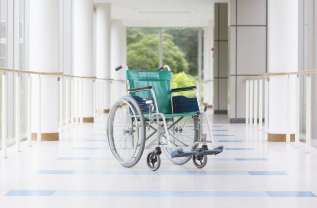wózek inwalidzki stojący na tle korytarza szpitalnego