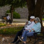 seniorzy siedzący na ławce w parku